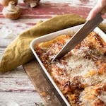 Slicing of Lasagna on a Ceramic Tray